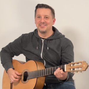 Ein Gitarrist mit einer akustischen Gitarre von Yamaha gibt Gitarrenunterricht in Bergisch Gladbach.